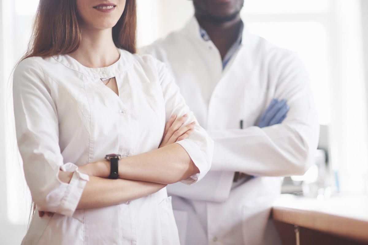 Two medical specialists in white coats representing multi-specialist supervision in cosmetic safety-in-use studies
